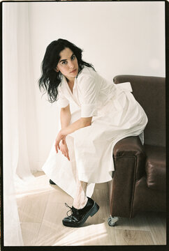 Woman in white dress sitting forward