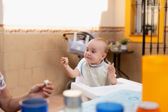 Baby eating bread at table