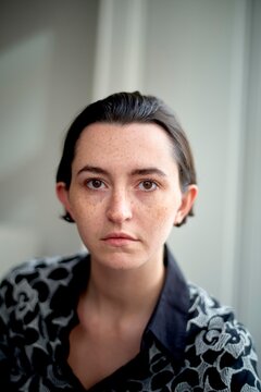 Person With Freckles Gazes Directly at the Camera Indoors