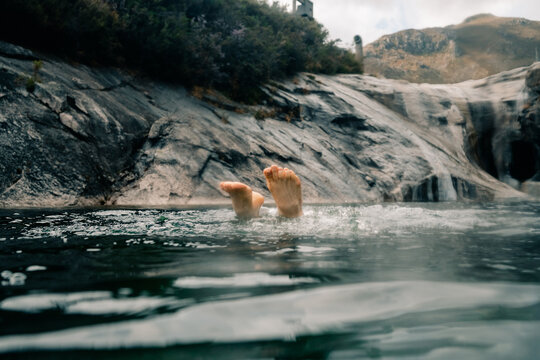 Swimming in a Natural Pool Beneath a Rocky Landscape