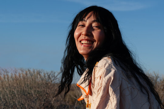 Model posing with oversized jacket in rocky desert