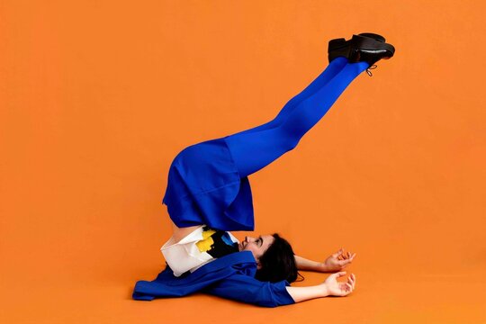 Woman stand yoga pose on orange background