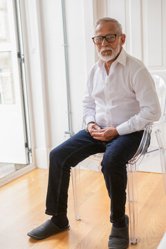 Elderly Man Sitting Comfortably in a Cozy Indoor Space