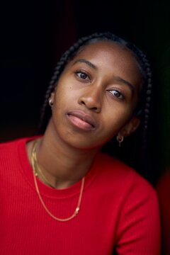 Portrait of a Thoughtful Young Woman With Braids in a Red Sweater