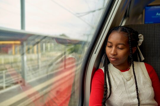 Young Woman Resting by the Window on a Train Journey