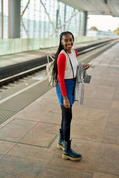 Young Traveler Awaits Train With Style at Modern Station