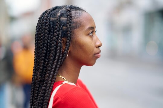 Profile of a Woman With Beautiful Braids in a Vibrant Street Setting