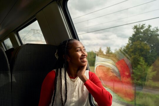 Young Woman Enjoys Train Journey Through Scenic Countryside