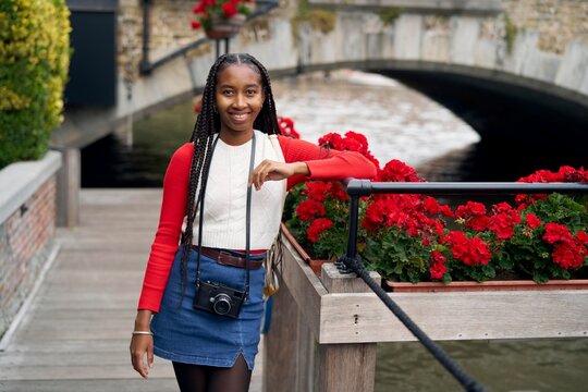 Young Girl Enjoys a Delightful Moment Near a Canal With Flowers
