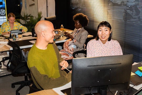 Cheerful colleagues working jointly at office