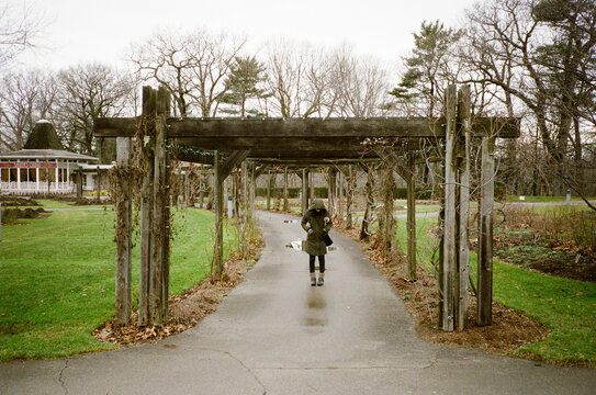 Woman green coat on a wet fall day at the botanical gardens