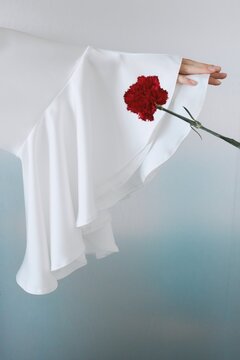 Elegant fashion detail with red flower and flowing sleeve