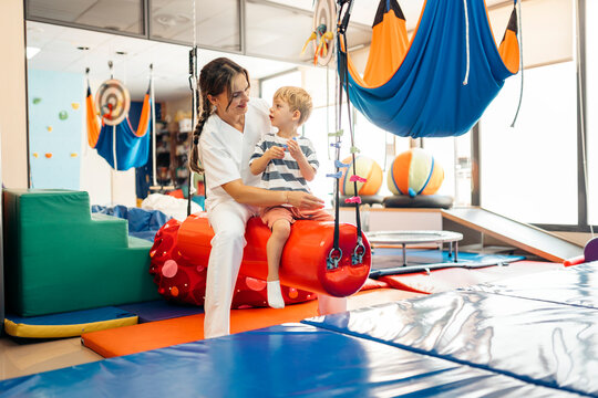 Physiotherapist assisting child during pediatric physical therapy
