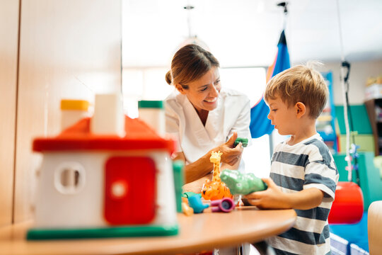 Child development specialist engaging with boy using psychomotor