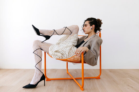Queer man posing in high heels and tights