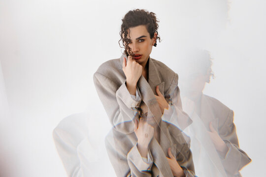 Queer man posing in stylish blazer with multiple exposure effect