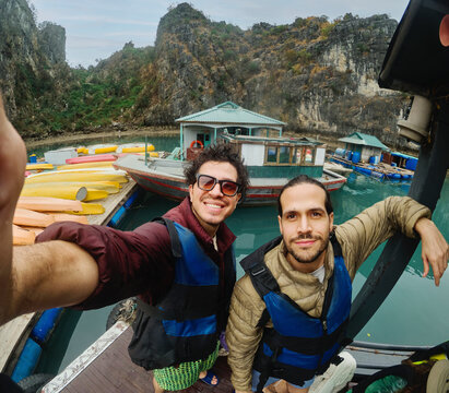 Two men standing by kayaks in Halong Bay Vietnam