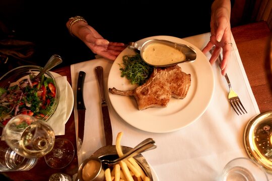 Delicious Pork Chop Served With Sides in a Cozy Restaurant Setting