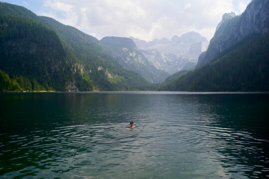 Swimmer Enjoys the Calm Lake Surrounded by Mountains
