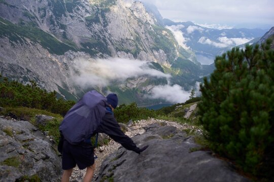 Adventurer Climbing Rocky Trail in Breathtaking Mountain Landscape