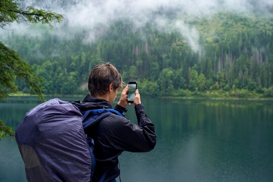 Hiker Capturing the Beauty of Nature by the Serene Lake