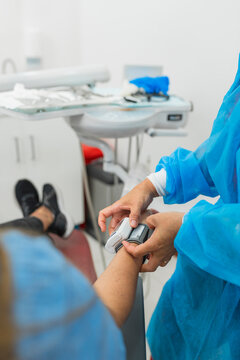 Dentist placing blood pressure monitor on patient