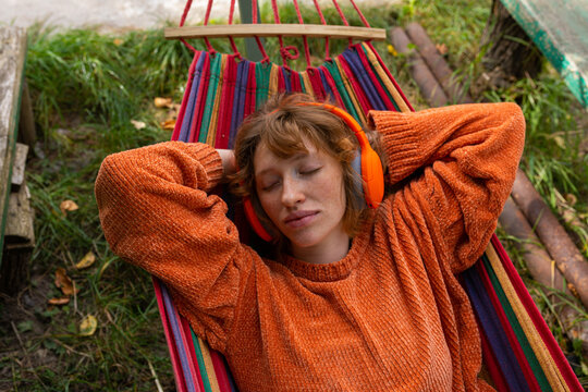 Portrait of a girl with headphones in a hammock