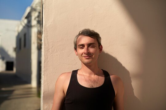 Young Man Relaxing in a Sunny Alleyway During Late Afternoon