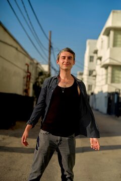 Man Standing Confidently in a Sunny Urban Alleyway