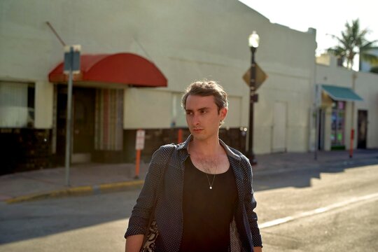 Man Walking on a Sunny Street in a Vibrant Urban Setting