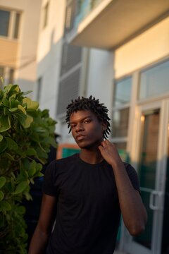 Young Man Posing Confidently in Urban Setting During Golden Hour