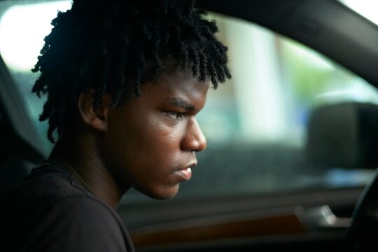 Young Man Deep in Thought While Sitting in a Car