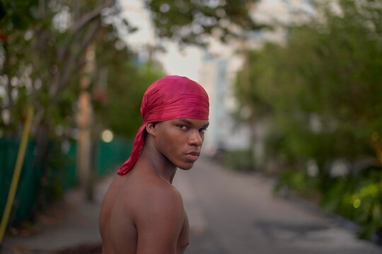 Young Man With Red Durag on Street in Urban Setting