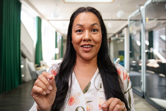Smiling woman in a modern office setting during a conference call