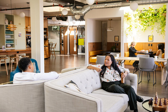 Colleagues relaxing in a modern workspace lounge with open layout