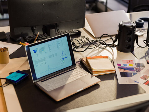 Laptop on chaotic office desk