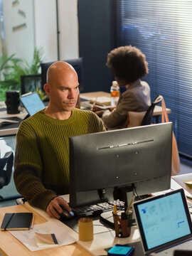 Focused Man Working at a Desk in a Modern Office