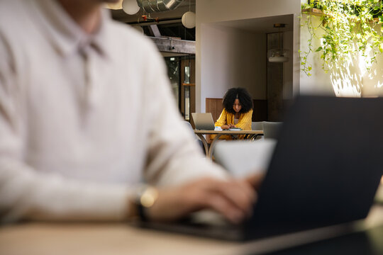 Casual workspace with focus on woman working on a laptop indoors