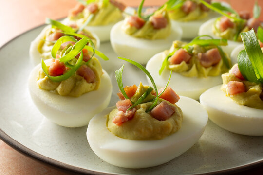A closeup view of a plate of deviled eggs green eggs and ham.