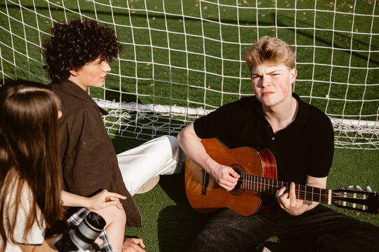 Group listens to music on a sunny field