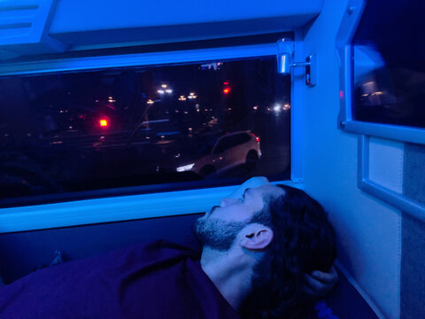 Man resting on sleeper bus at night
