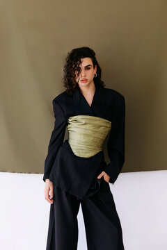 Queer person posing in fashion blazer and corset