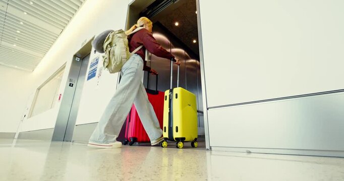 Person Exits with Luggage in Modern Elevator Lobby