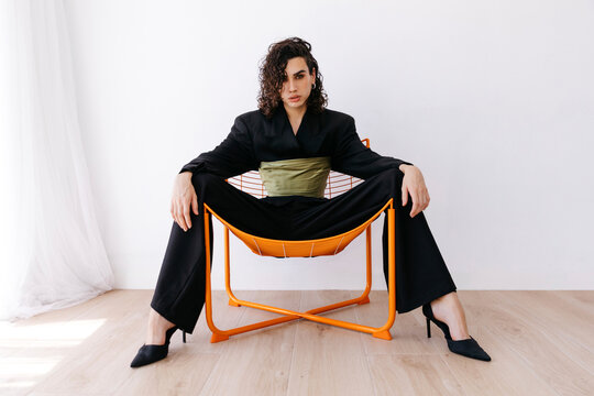 Queer man on chair posing 