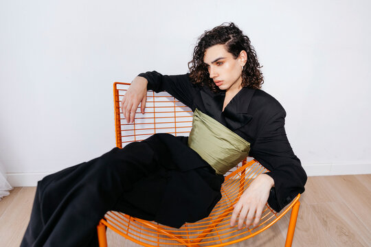 Queer man sitting on chair