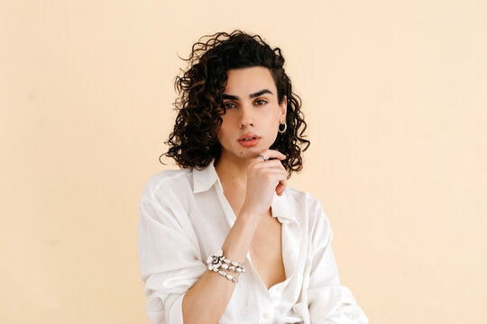 Queer man touching his chin at studio