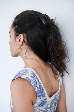 Portrait of a Woman With Curly Hair and a Hair Clip in a Calm Setting