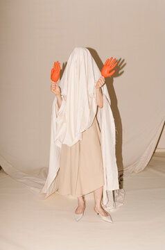 Beige Cloaked Figure With Orange Gloves