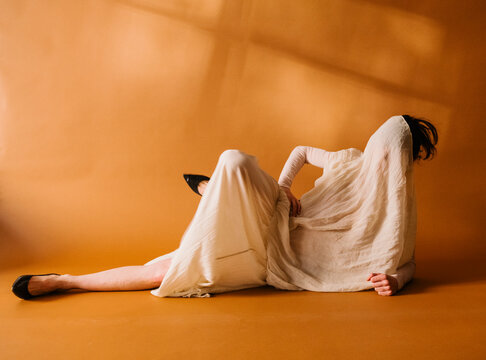 Draped Figure on Orange Studio Floor