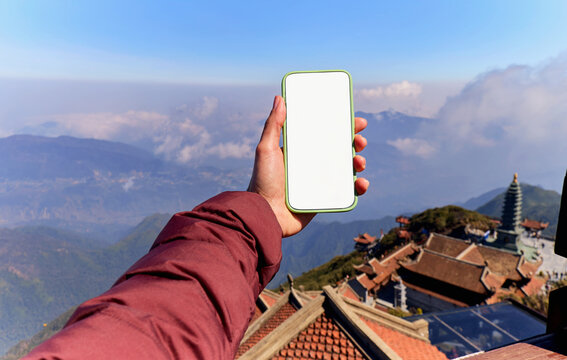 Smartphone with blank screen against mountain backdrop